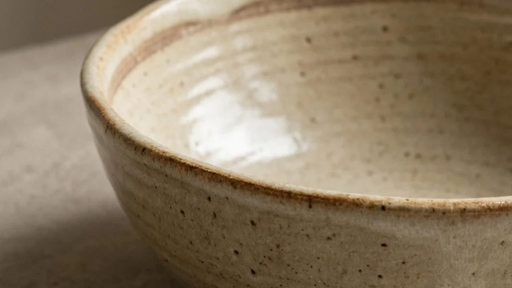 Close-up of a ceramic bowl's rim and glazed interior surface.